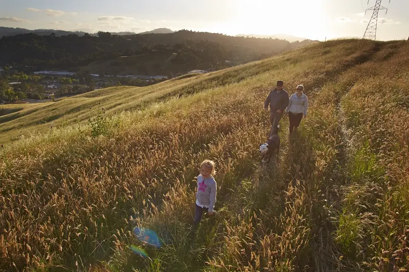 A young family in the evening light hiking across Painted Rock